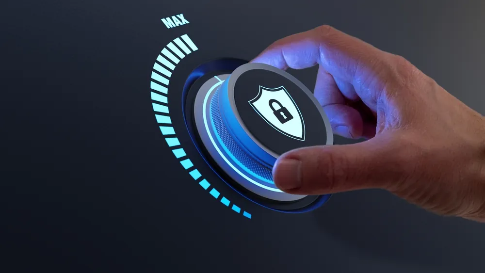 Hand turning a digital security lock dial towards maximum setting with illuminated blue interface.