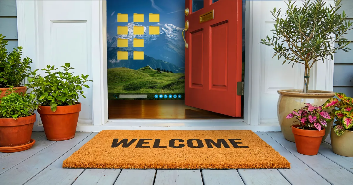 Open red door with a welcome mat and potted plants revealing a computer desktop screen with mountain wallpaper inside.